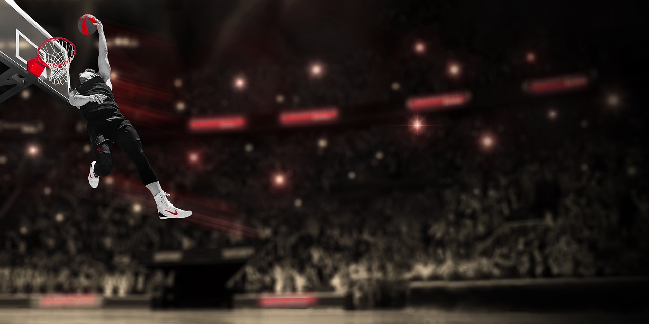 A professional basketball player performing a powerful slam dunk